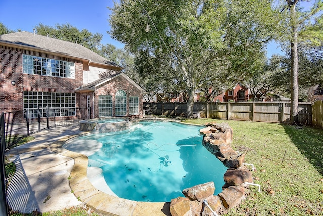 view of pool featuring a yard and an in ground hot tub