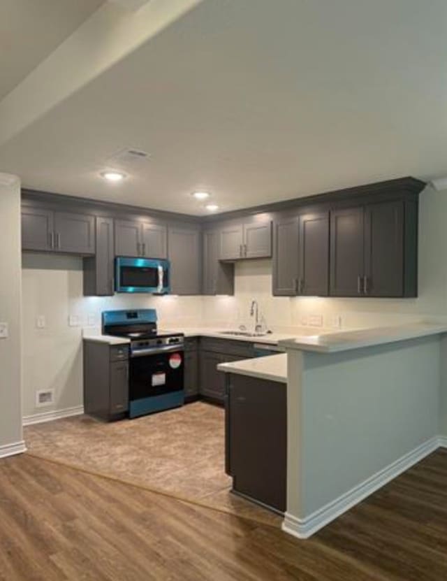 kitchen featuring dark hardwood / wood-style flooring, black range with electric cooktop, gray cabinets, and sink