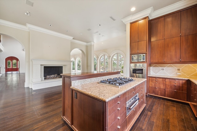 kitchen with stainless steel appliances, a kitchen island, dark hardwood / wood-style floors, and ornamental molding