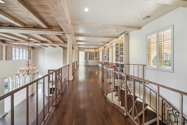 hallway with beam ceiling, dark hardwood / wood-style flooring, and an inviting chandelier