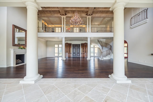 unfurnished living room featuring wood-type flooring, an inviting chandelier, and beam ceiling