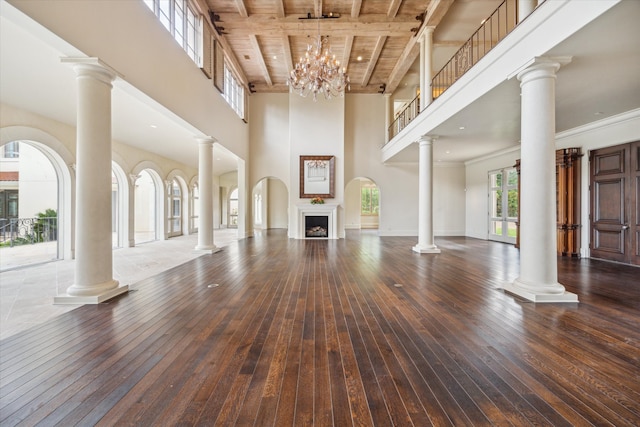 unfurnished living room with a chandelier, a high ceiling, hardwood / wood-style flooring, and wooden ceiling