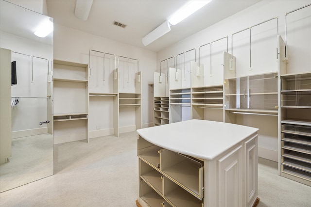 walk in closet featuring light carpet