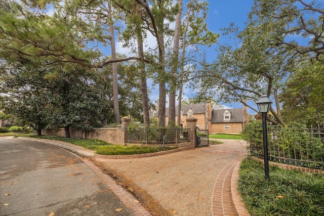 view of road featuring a gate and curbs