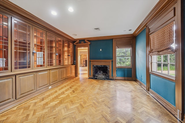 unfurnished living room with crown molding, light parquet flooring, and a premium fireplace