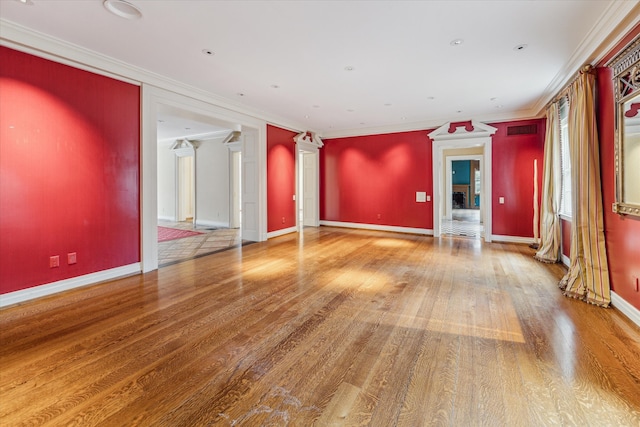 unfurnished living room with hardwood / wood-style floors, ornamental molding, and ornate columns