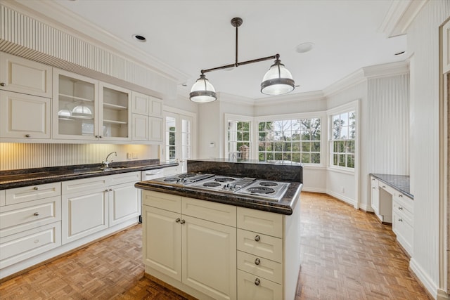 kitchen featuring white gas cooktop, light parquet flooring, a kitchen island, and a healthy amount of sunlight