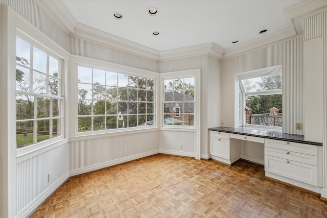 unfurnished sunroom featuring built in desk and plenty of natural light