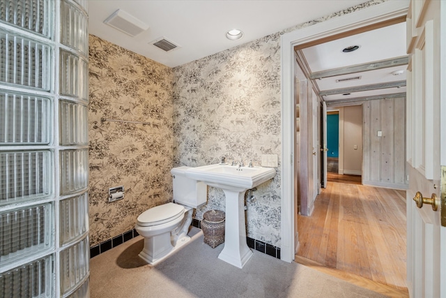 bathroom with hardwood / wood-style flooring and toilet