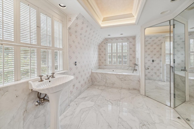 bathroom with a tray ceiling, a garden tub, crown molding, and wallpapered walls