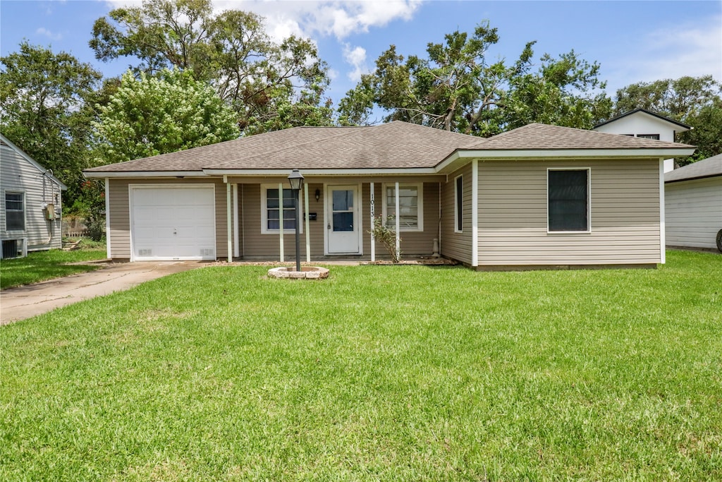 single story home featuring cooling unit, a garage, and a front yard