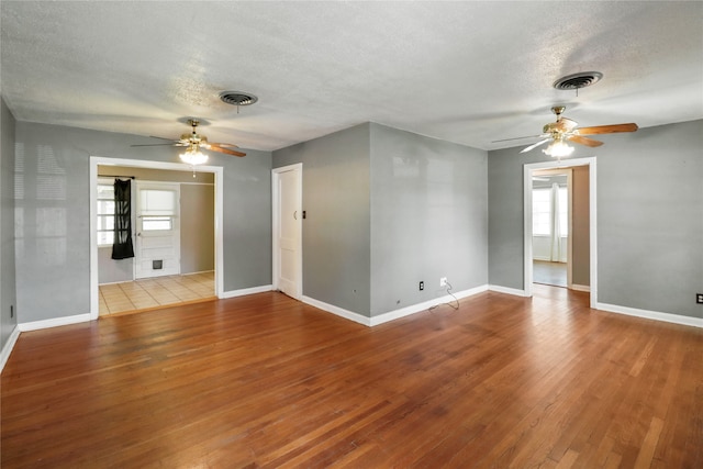 empty room featuring light hardwood / wood-style flooring, a healthy amount of sunlight, and a textured ceiling