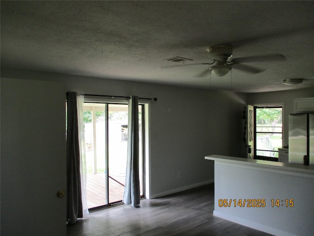 319 River Rd, Goodrich, TX 77335 - unfurnished room featuring a ceiling fan, dark wood-style flooring, baseboards, and a textured ceiling