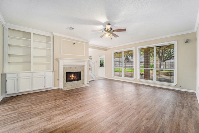 unfurnished living room featuring hardwood / wood-style flooring, ceiling fan, a fireplace, and a textured ceiling