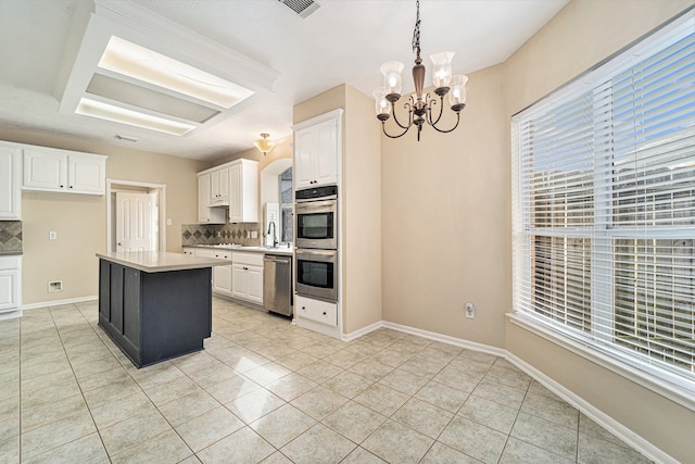 kitchen with white cabinets, backsplash, and stainless steel appliances