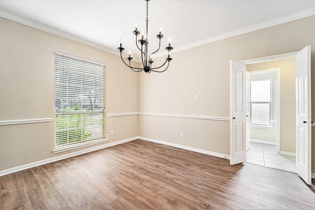 unfurnished room with ornamental molding, a chandelier, and hardwood / wood-style flooring