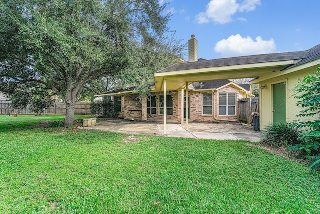 rear view of house with a lawn and a patio area