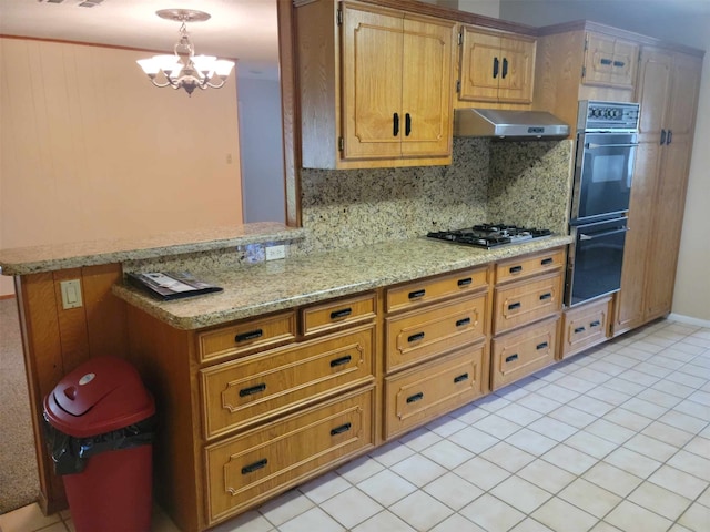 kitchen featuring an inviting chandelier, double oven, extractor fan, stainless steel gas stovetop, and light tile patterned flooring