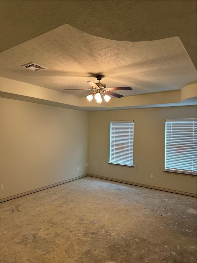 spare room featuring ceiling fan, concrete flooring, and a textured ceiling