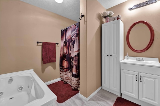 bathroom featuring vanity, a textured ceiling, and a tub to relax in