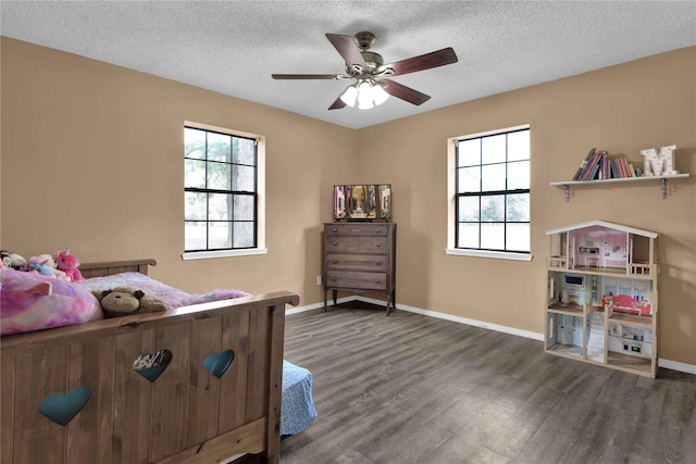 bedroom featuring dark hardwood / wood-style floors, ceiling fan, and a textured ceiling