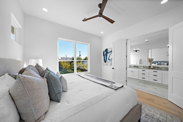 bedroom with ensuite bath, ceiling fan, and light wood-type flooring