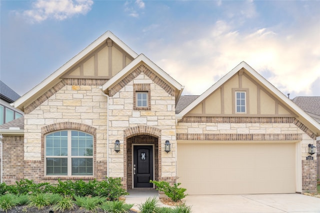 english style home featuring a garage