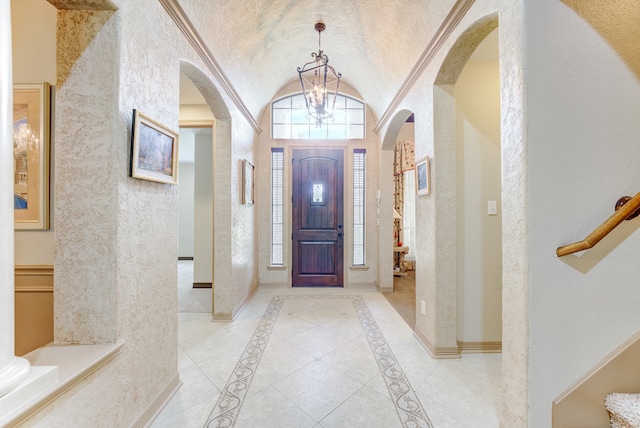 entrance foyer featuring a notable chandelier, lofted ceiling, and light tile patterned floors