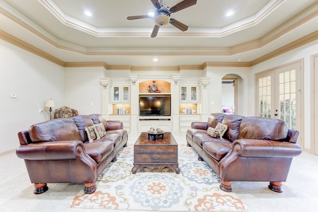 living room featuring a tray ceiling, crown molding, and ceiling fan