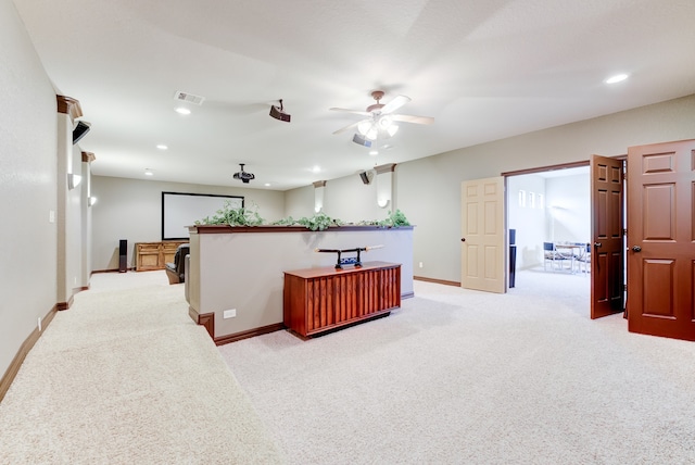 kitchen featuring kitchen peninsula, light carpet, and ceiling fan