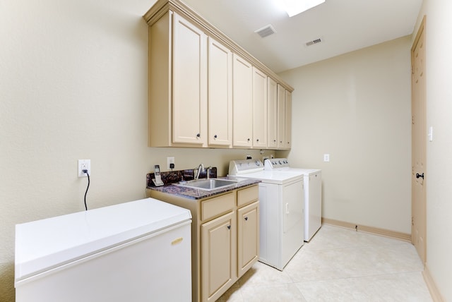 clothes washing area with light tile patterned flooring, cabinets, sink, and washing machine and clothes dryer