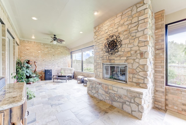 interior space featuring an outdoor living space with a fireplace and ceiling fan