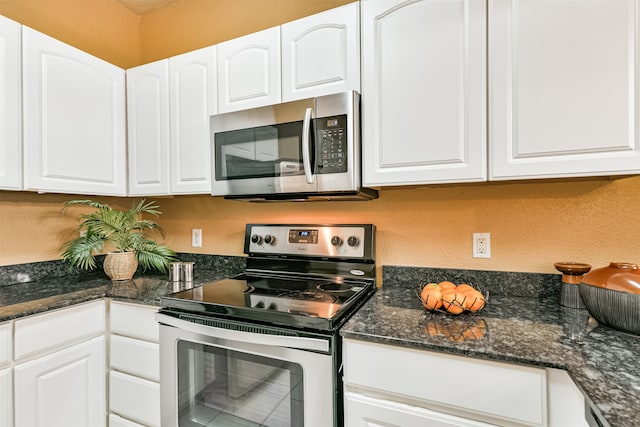 kitchen featuring white cabinets, dark stone counters, and appliances with stainless steel finishes