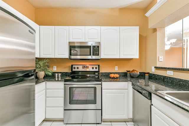 kitchen featuring dark stone counters, white cabinetry, light tile patterned flooring, and stainless steel appliances