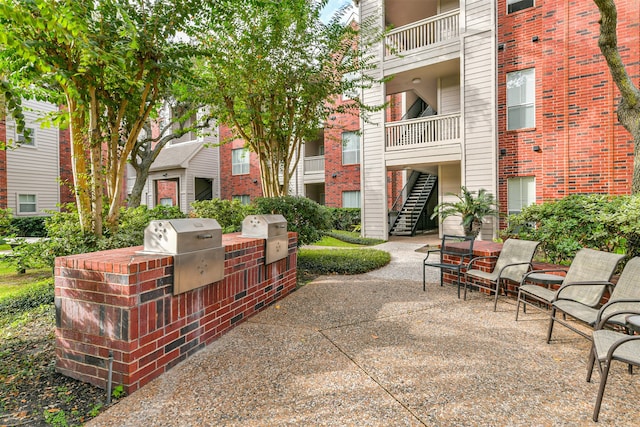 view of property's community featuring a patio and an outdoor kitchen