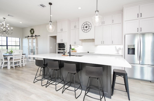 15007 Barak Rd Unit P, Guy, TX 77444 - kitchen with appliances with stainless steel finishes, a barn door, a sink, light wood finished floors, and recessed lighting