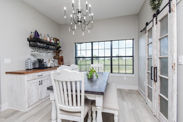 15007 Barak Rd Unit P, Guy, TX 77444 - dining space featuring light wood-style floors, a chandelier, baseboards, and a barn door