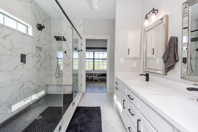 bathroom featuring tile patterned flooring, a tile shower, and vanity