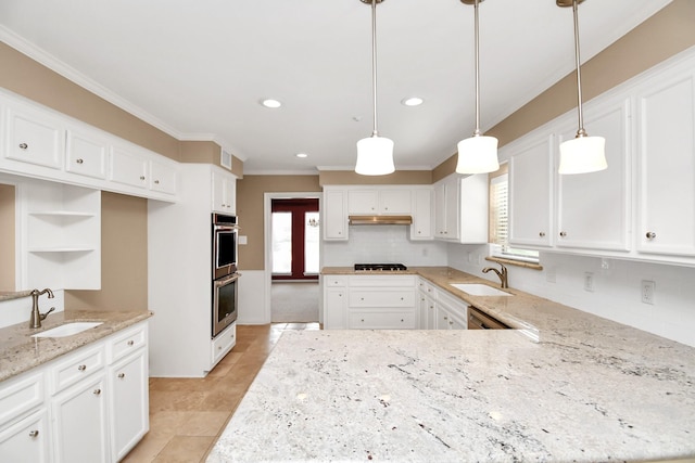 kitchen with white cabinets, decorative light fixtures, stainless steel appliances, and sink