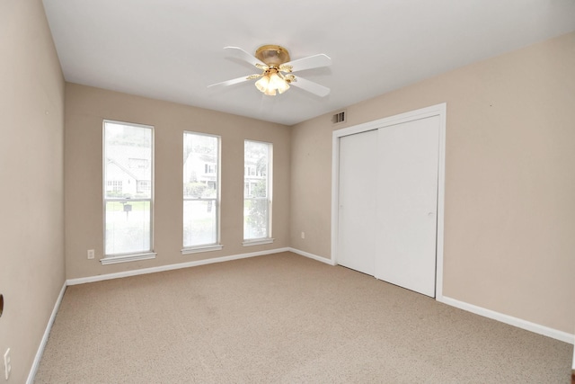 unfurnished bedroom with ceiling fan, a closet, and carpet floors