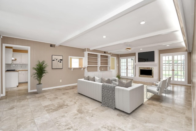 living room with ceiling fan, beam ceiling, a premium fireplace, and french doors