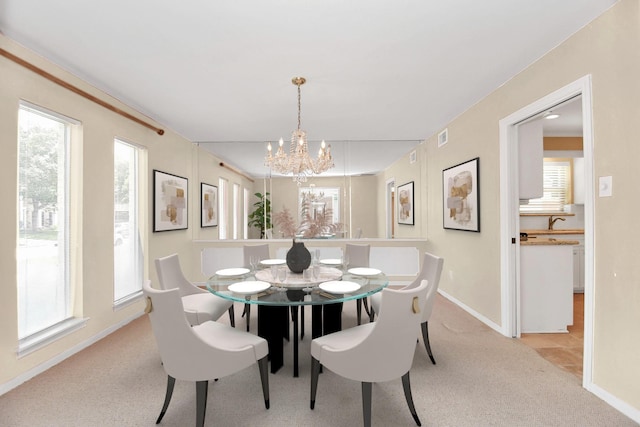 dining area with light carpet, sink, and a notable chandelier