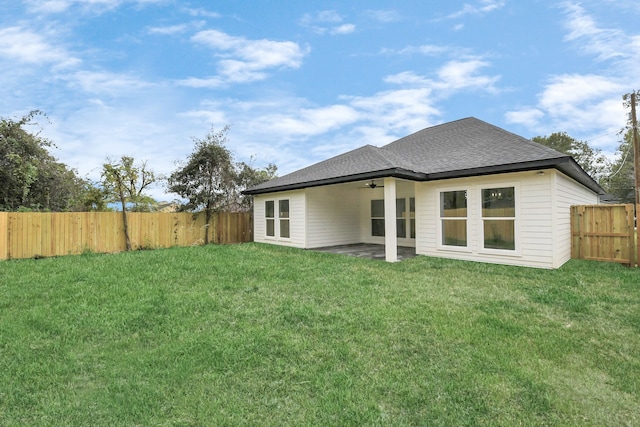 rear view of house featuring a lawn, ceiling fan, and a patio area