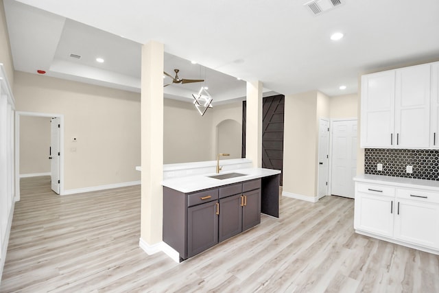 kitchen with white cabinets, light hardwood / wood-style floors, and sink