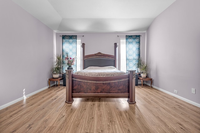 bedroom featuring lofted ceiling and light hardwood / wood-style flooring