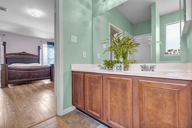 bathroom with walk in shower, vanity, and hardwood / wood-style flooring