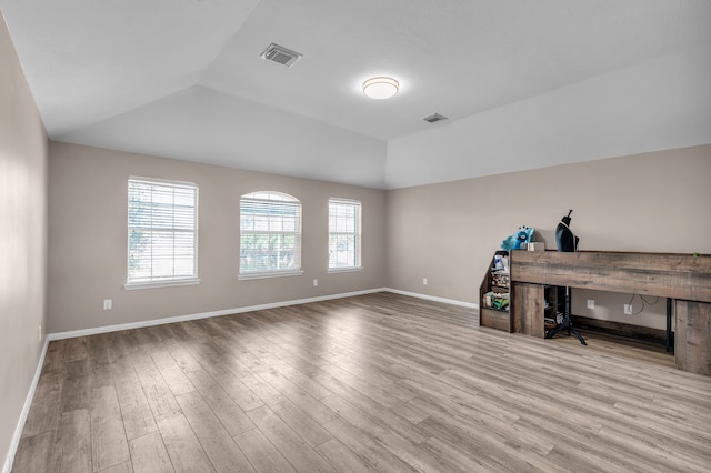 office with light hardwood / wood-style floors, lofted ceiling, and a wealth of natural light