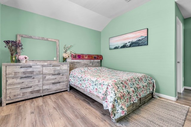 bedroom with lofted ceiling and light wood-type flooring