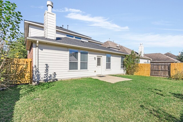 back of property with a lawn and a patio area