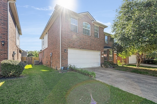 view of front of home featuring central AC, a garage, and a front lawn